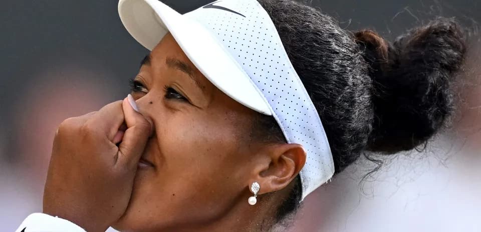 Jugadora de tenis con gorra y pendientes sonriendo