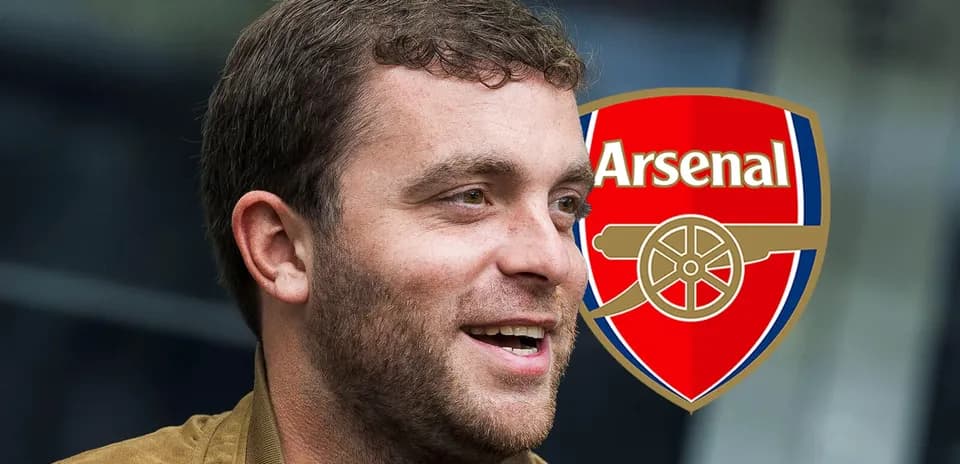 Persona sonriendo junto al escudo del Arsenal