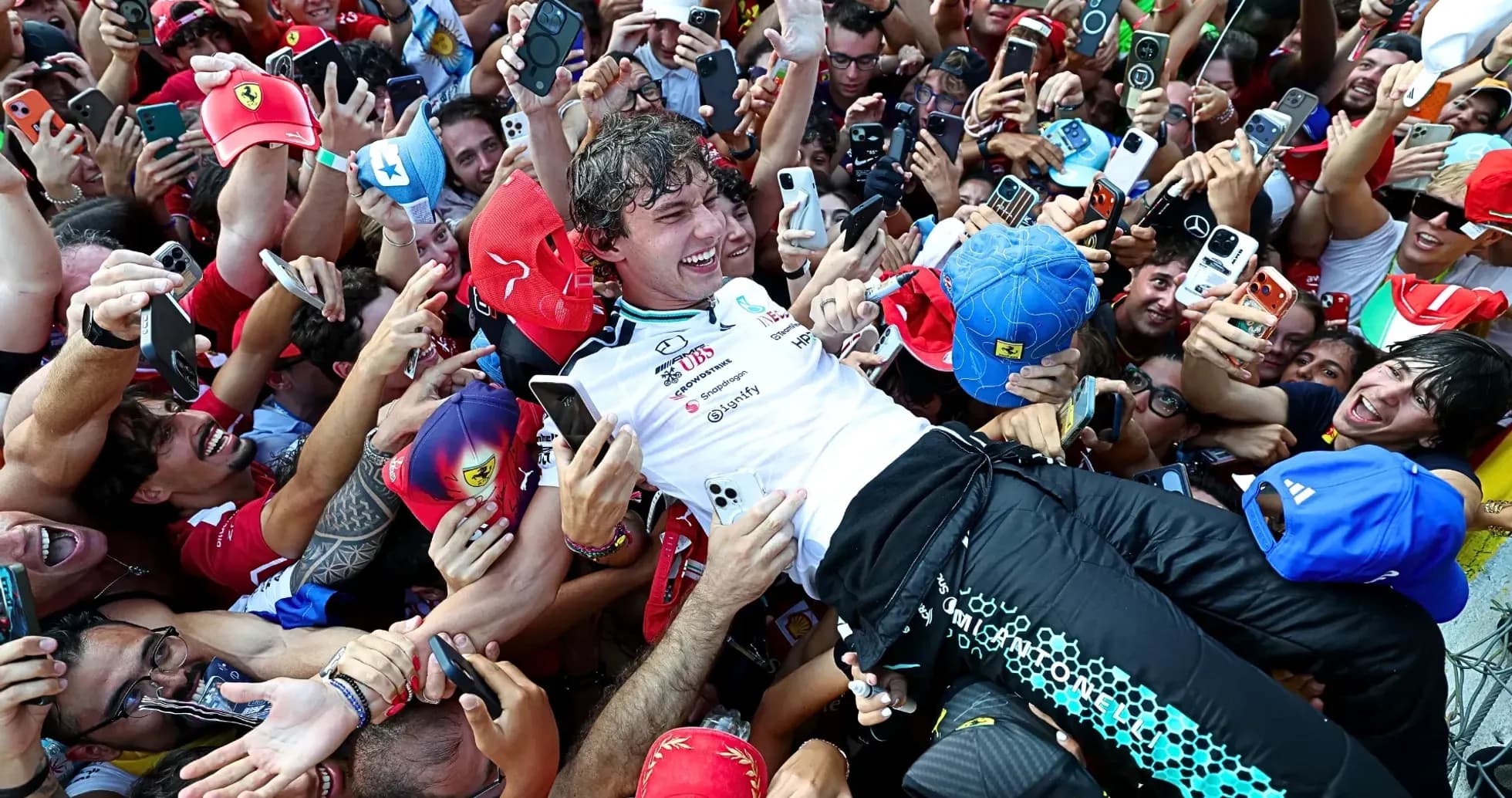 Piloto siendo levantado por la multitud de aficionados