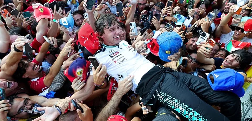Piloto siendo levantado por la multitud de aficionados