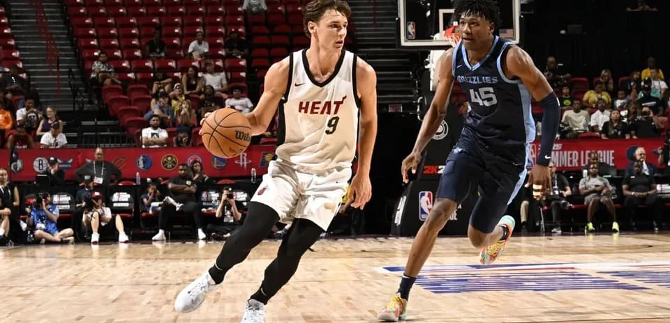 Jugador de Miami Heat driblando frente a defensor