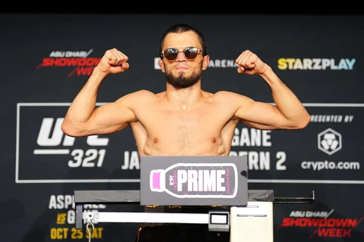 Luchador en la báscula mostrando músculos en evento UFC