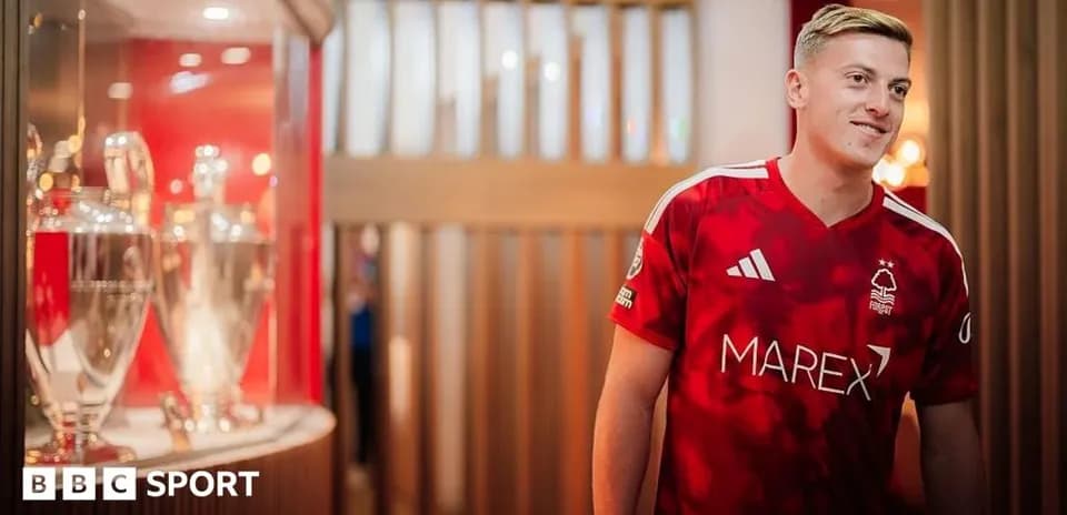 Jugador de Nottingham Forest en camiseta roja junto a trofeos
