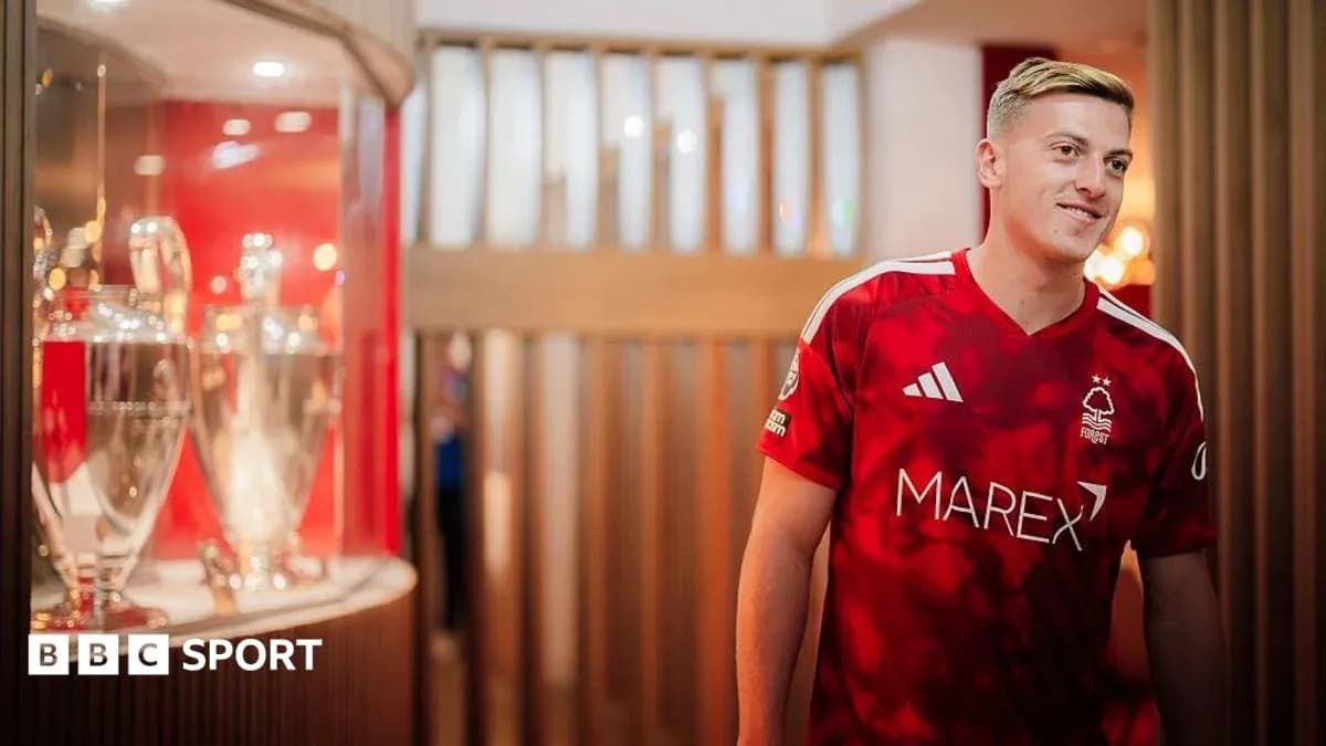 Jugador de Nottingham Forest en camiseta roja junto a trofeos