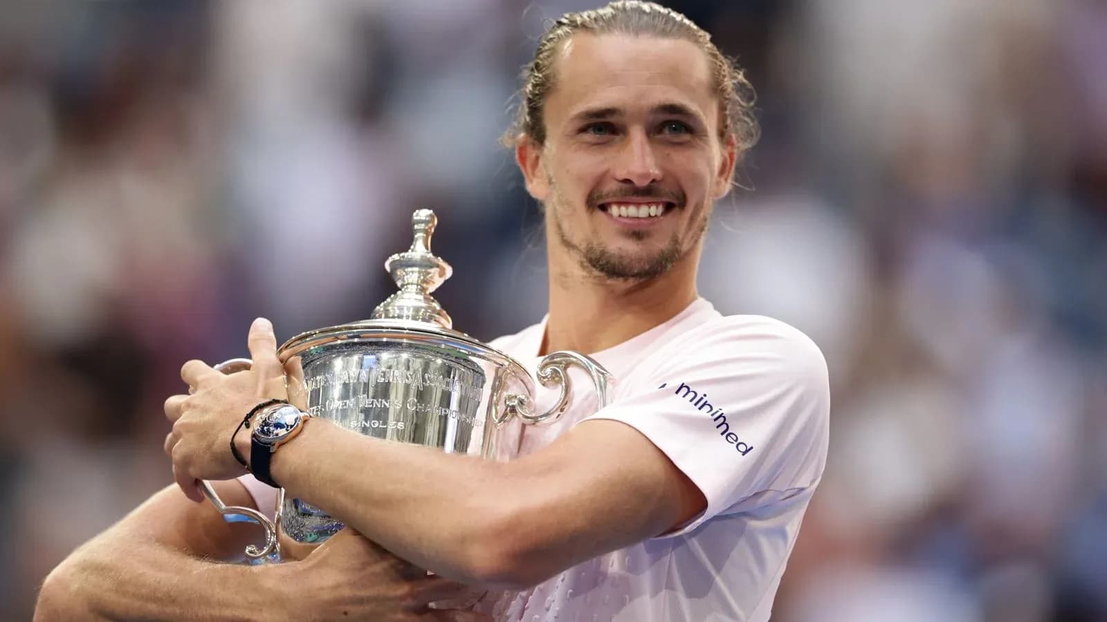 Jugador sosteniendo el trofeo de tenis sonriente Jugador sosteniendo el trofeo de tenis sonriente