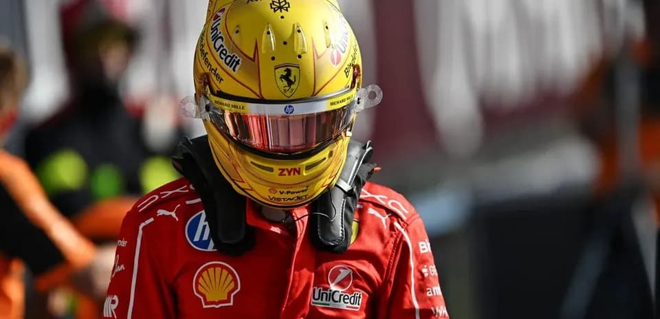 Piloto con casco amarillo y traje de Ferrari