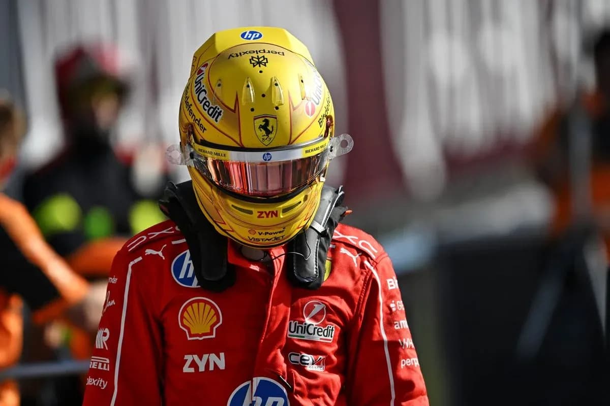 Piloto con casco amarillo y traje de Ferrari