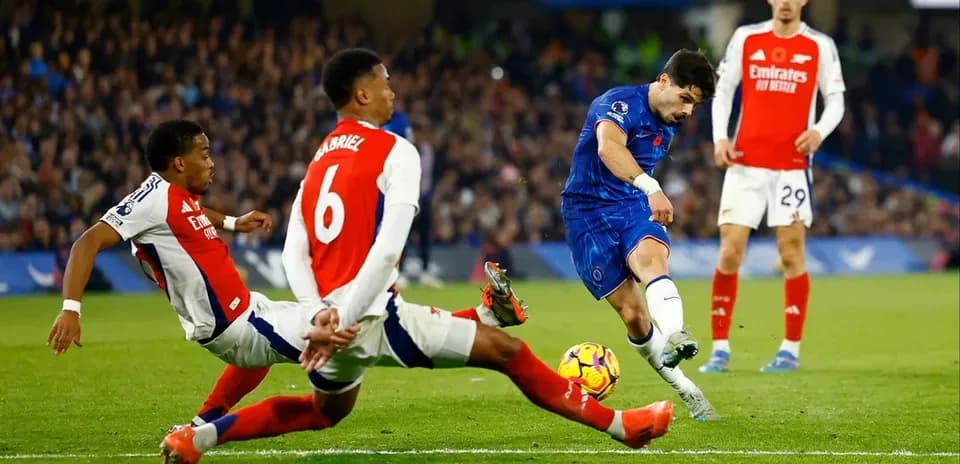 Jugador de Chelsea disparando mientras es desafiado