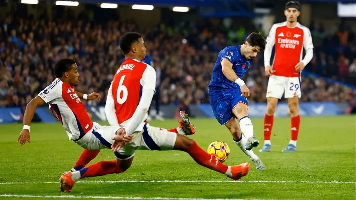 Jugador de Chelsea disparando mientras es desafiado