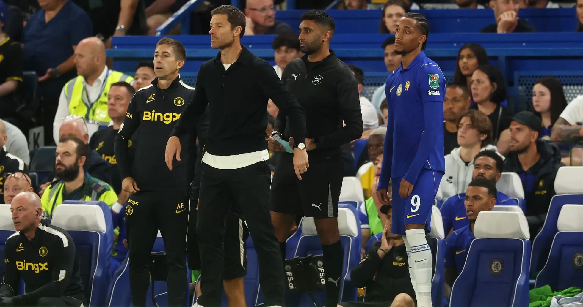 Entrenadores y jugador en el banquillo durante partido
