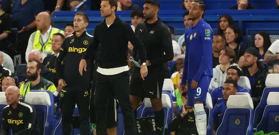 Entrenadores y jugador en el banquillo durante partido