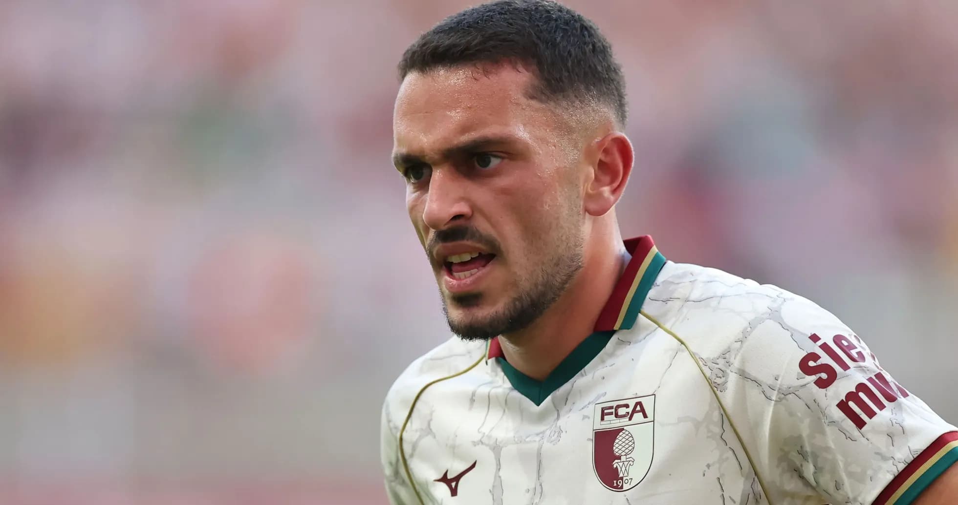Jugador de fútbol con camiseta del FC Augsburg en acción
