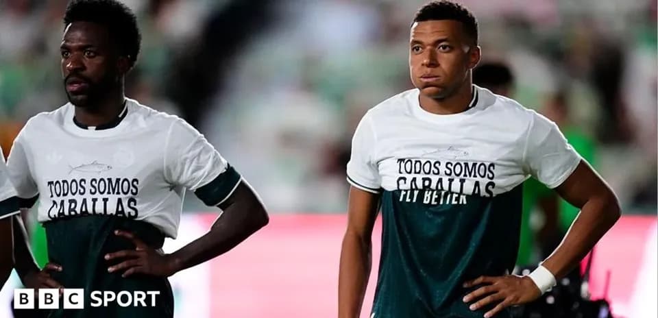 Jugadores en el campo con camisetas de calentamiento