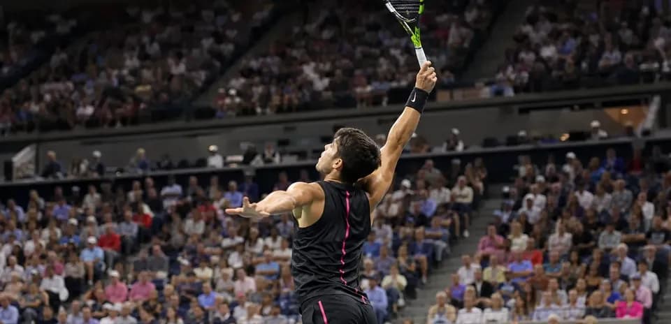Jugador de tenis sacando en partido con público
