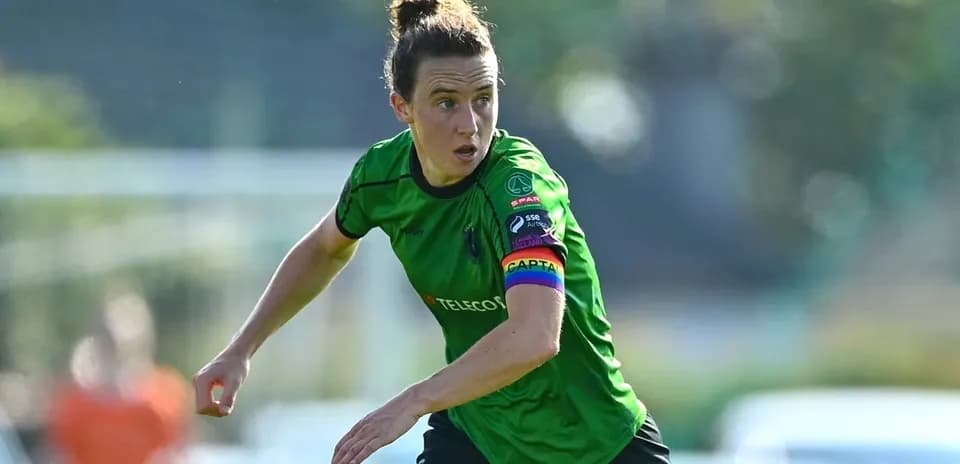 Jugadora en acción con camiseta verde y cinta de capitán