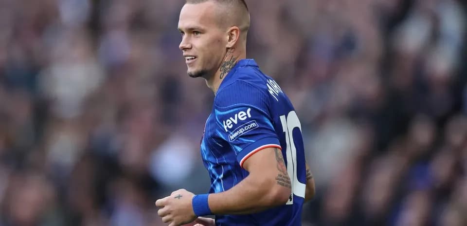 Jugador en uniforme azul sonriendo durante el partido