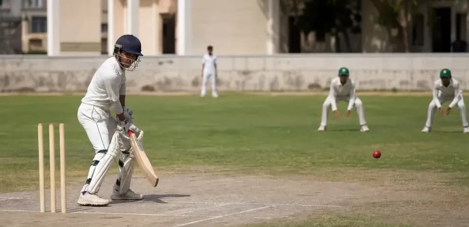 Jugador de cricket bateando mientras dos jugadores están en posición