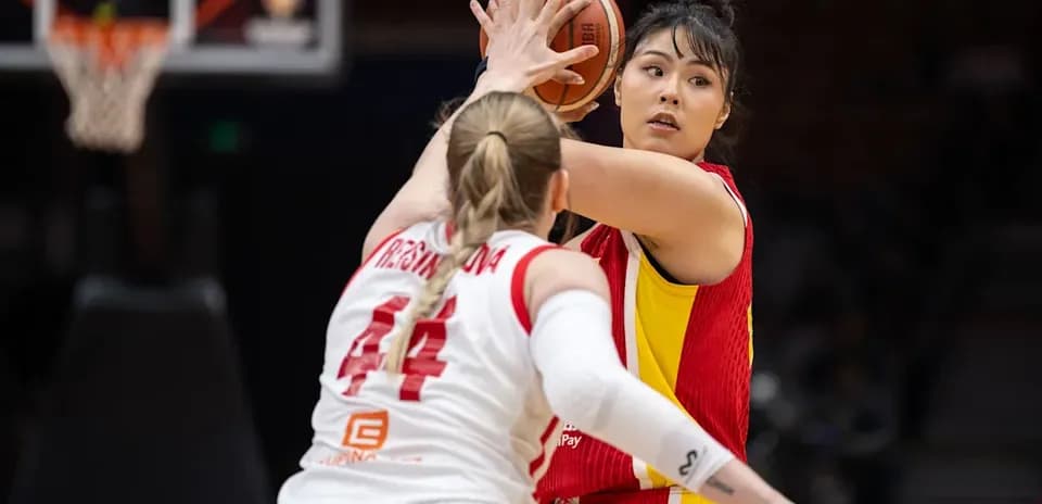 Jugadora pasando el balón en partido de baloncesto