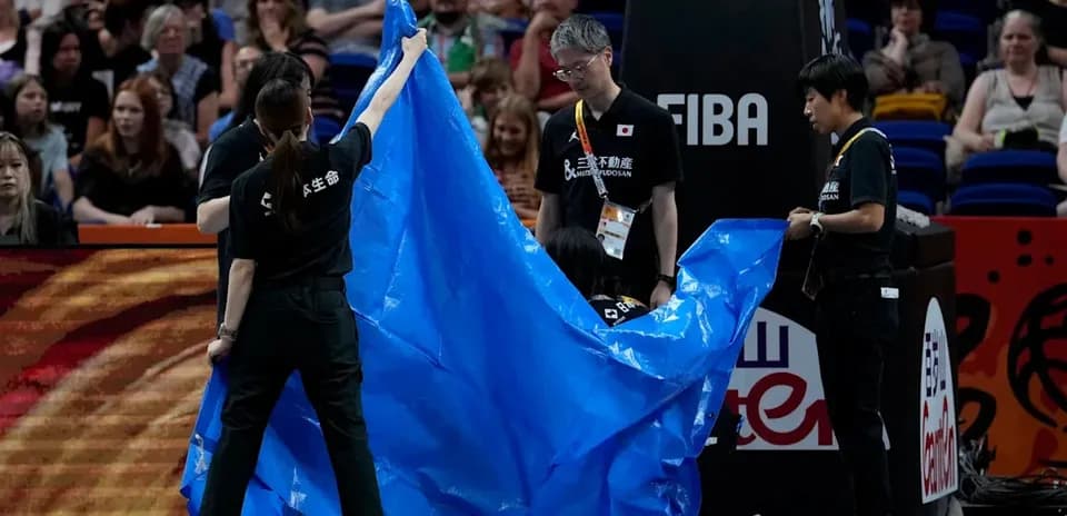 Personal de cancha cubriendo el área con una lona azul