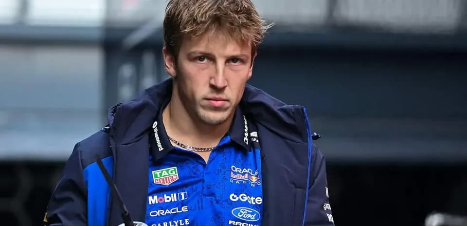 Piloto con chaqueta de equipo en el paddock
