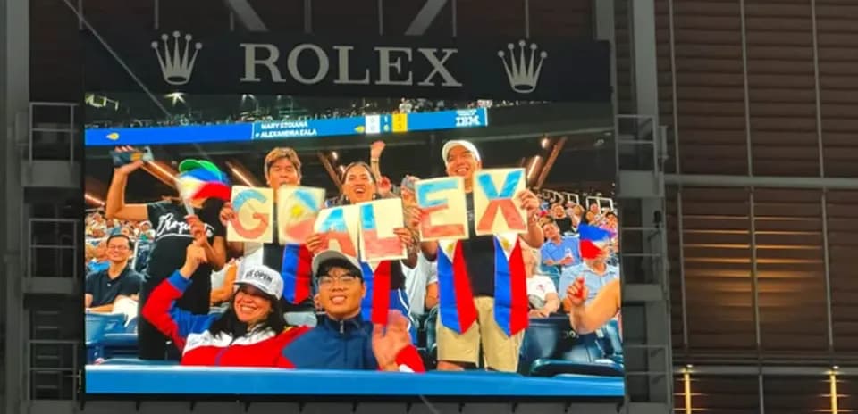 Espectadores animando con letreros en el estadio