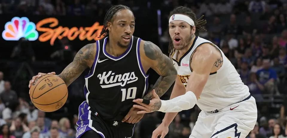 Jugador de los Kings driblando con balón, defendido por rival