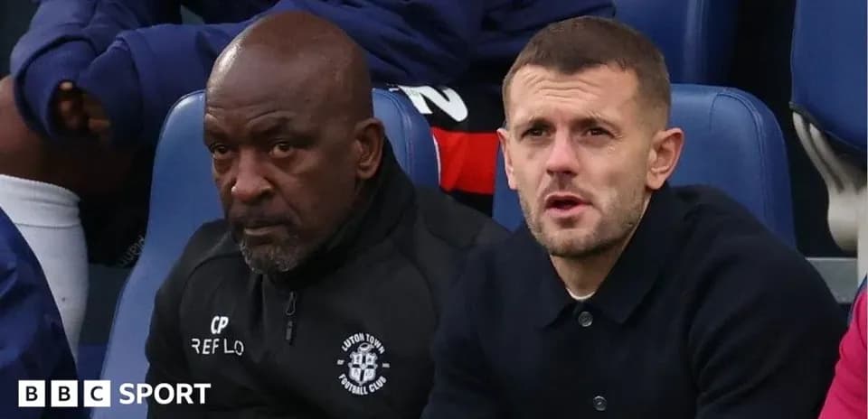Entrenador y jugador observando el partido desde el banquillo