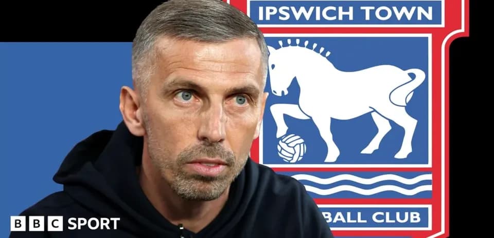 Entrenador hablando con logo de Ipswich Town de fondo