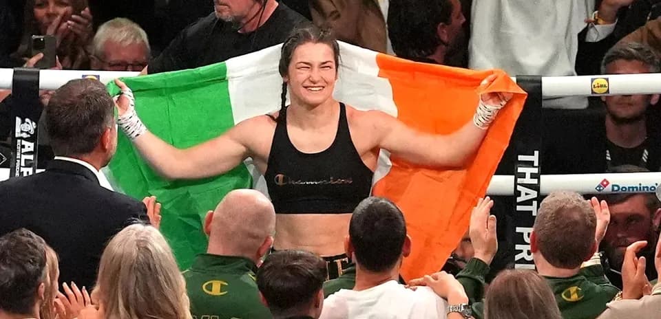 Boxeadora sosteniendo la bandera irlandesa tras ganar
