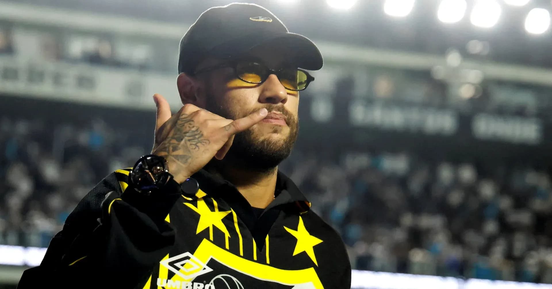 Persona haciendo un gesto de saludo en estadio
