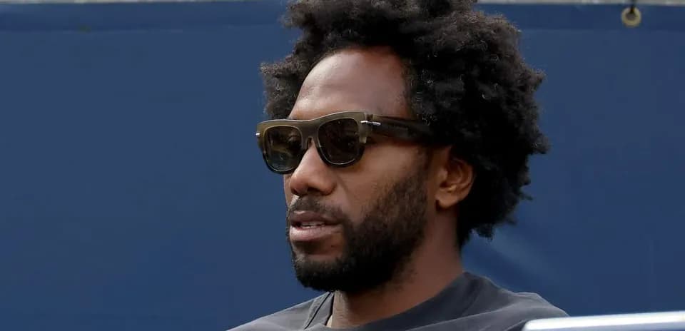 Hombre con gafas sentado en un evento deportivo