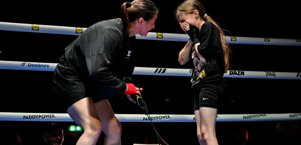 Boxeadora hablando con niña en el ring