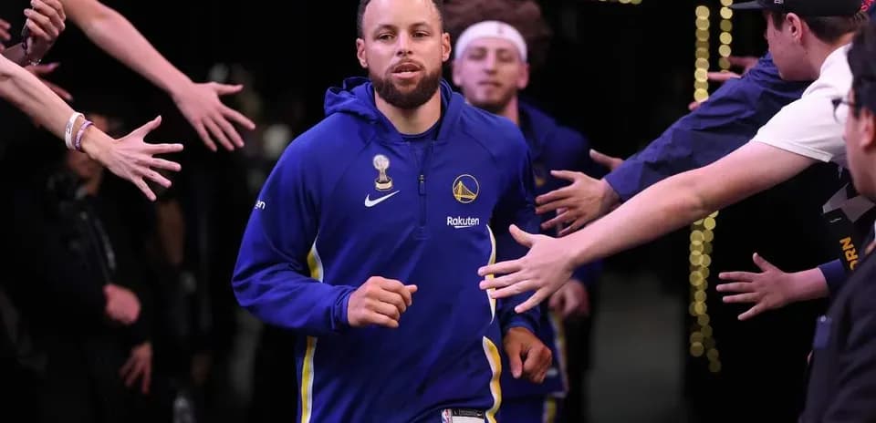 Stephen Curry corriendo hacia la cancha durante presentación