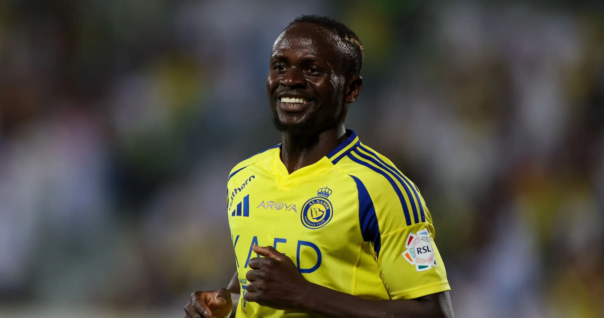 Jugador sonriente de Al Nassr en uniforme amarillo