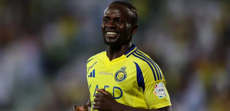 Jugador sonriente de Al Nassr en uniforme amarillo