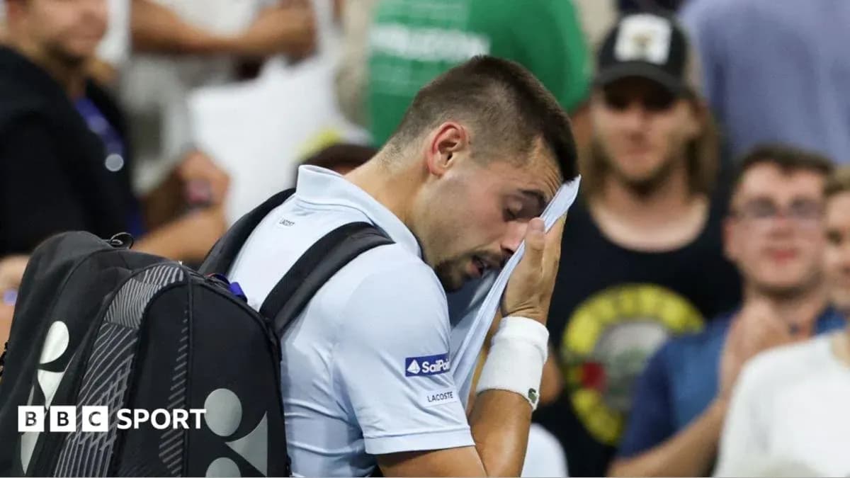 Jugador de tenis limpiándose el sudor en la cancha