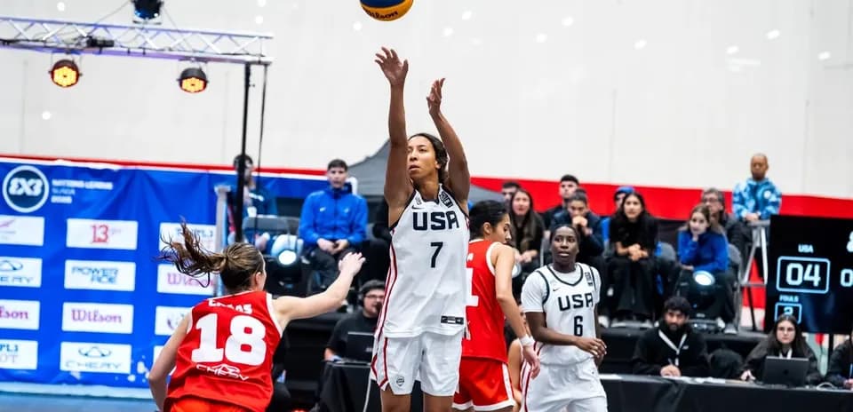 Jugadora de baloncesto lanzando en partido internacional