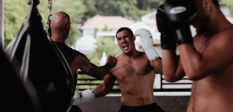 Boxeadores entrenando en gimnasio con sacos de boxeo