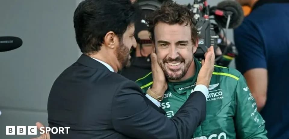 Fernando Alonso sonriendo con un hombre en traje