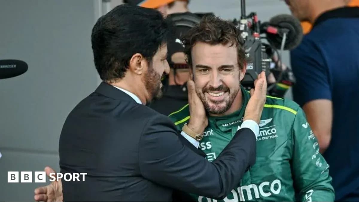 Fernando Alonso sonriendo con un hombre en traje