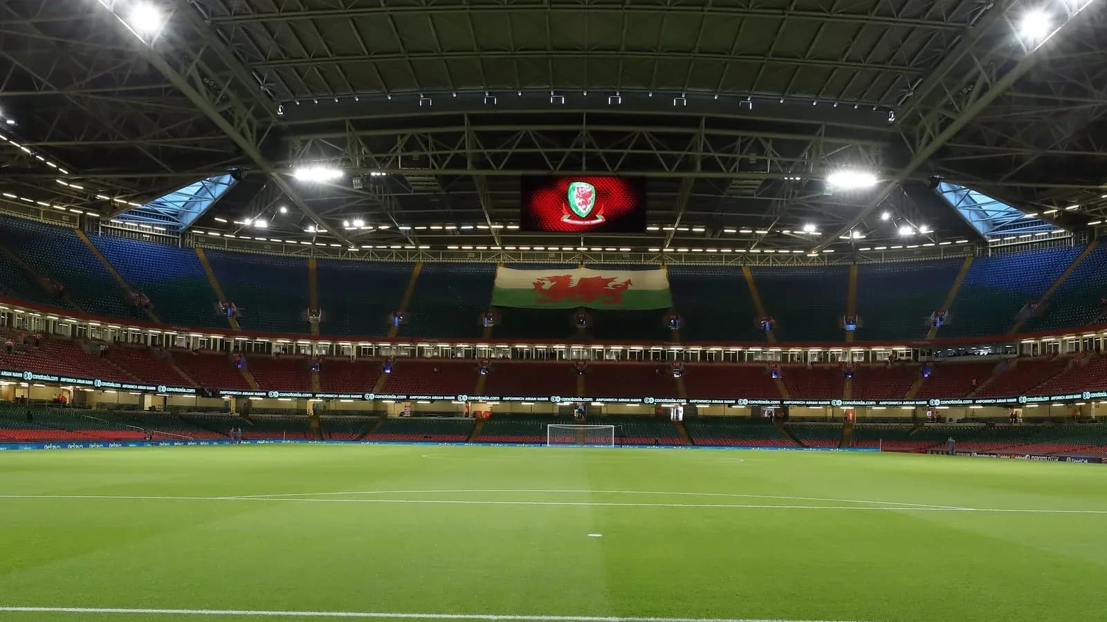 Estadio con césped y bandera de Gales visible