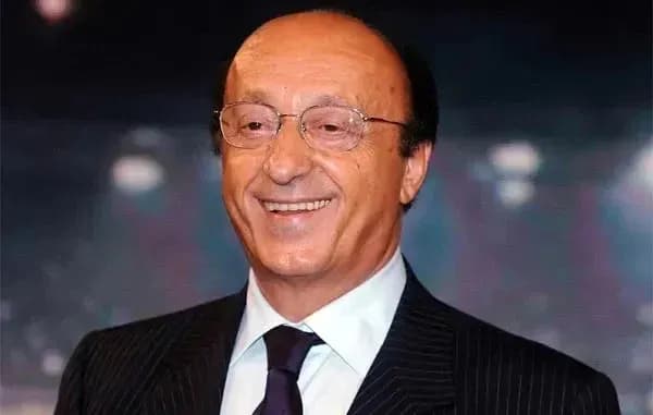 Hombre sonriendo con traje y gafas en evento