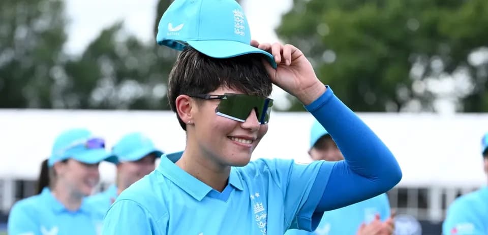 Jugadora de críquet con gorra en mano