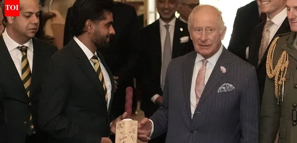 Jugador de críquet entregando un regalo a Carlos III