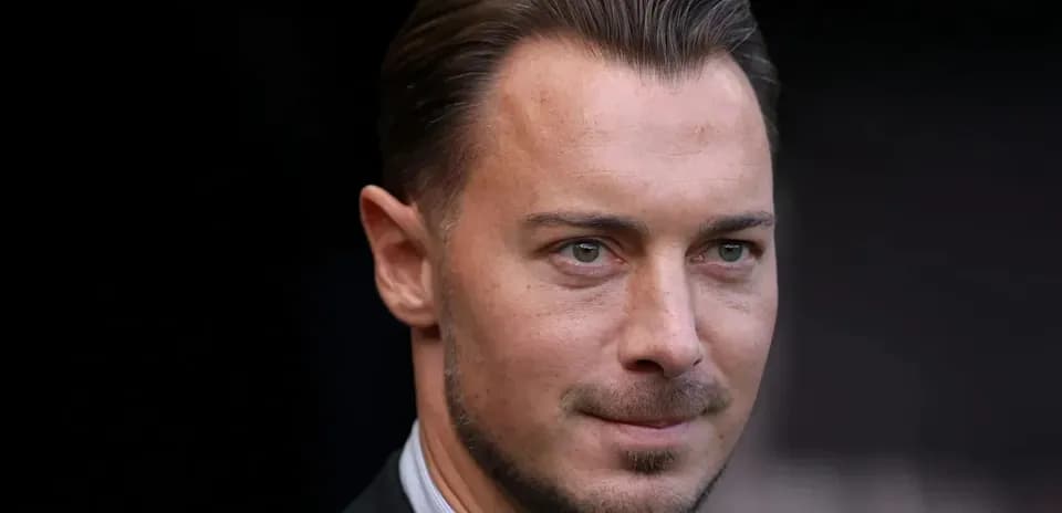 Hombre de pie con traje y mirada seria