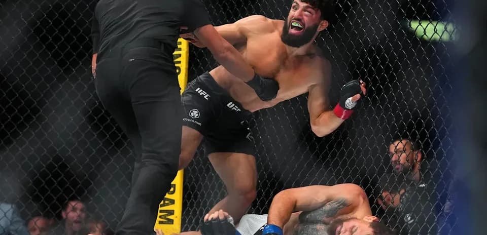 Luchador celebra mientras árbitro detiene la pelea