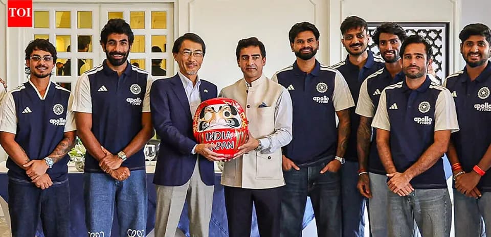 Equipo de cricket posando con figura Daruma
