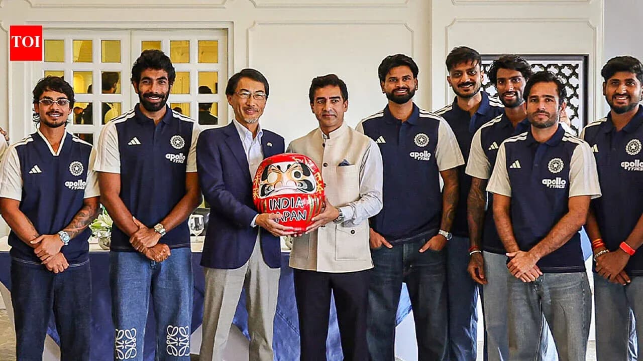 Equipo de cricket posando con figura Daruma