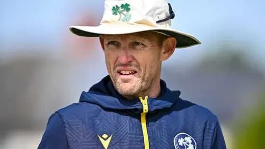Entrenador de cricket con sombrero en el campo