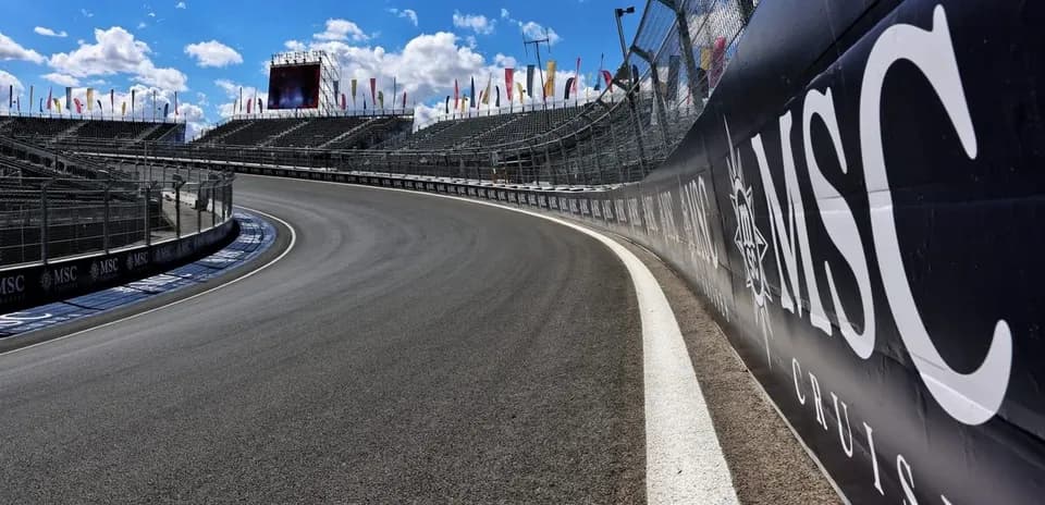 Curva de pista con gradas vacías y cielo azul